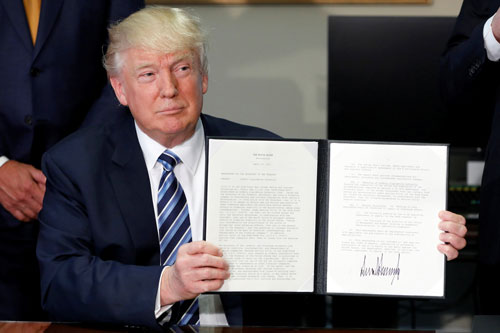 Tổng thống Mỹ Donald Trump ký ban hành một sắc lệnh hành pháp hôm 21-4 Ảnh: REUTERS
