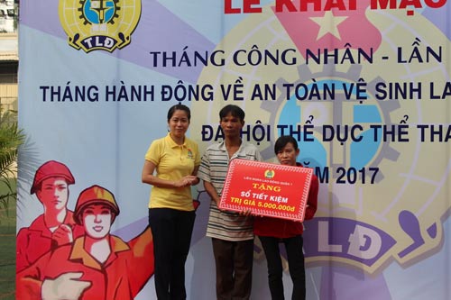 Bà Trương Thị Minh Dung - Chủ tịch LĐLĐ quận 1, TP HCM (trái) - trao sổ tiết kiệm cho đoàn viên khó khăn