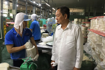 Ông Phạm Văn Tứ (áo trắng) và công nhân Công ty Thuận Phong đang sản xuất bánh tráng xuất khẩu sang Mỹ. Ảnh: C.H