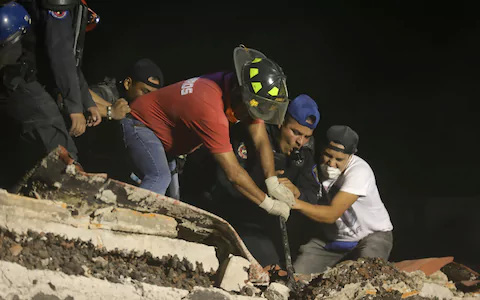 
Lực lượng cứu hộ đào bới đống đổ nát của một tòa nhà. Ảnh: AP
