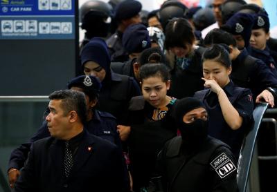 Nghi phạm Siti Aisyah mặc áo chống đạn bị bao vây bởi cảnh sát. Ảnh: Reuters