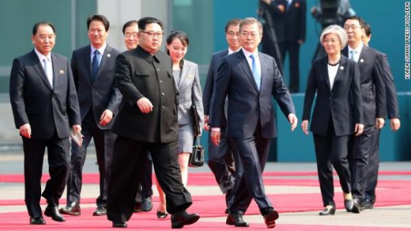 South Korean President Moon Jae-in (center right) and North Korean leader Kim Jong Un (center left) walk together with members of their delegations.