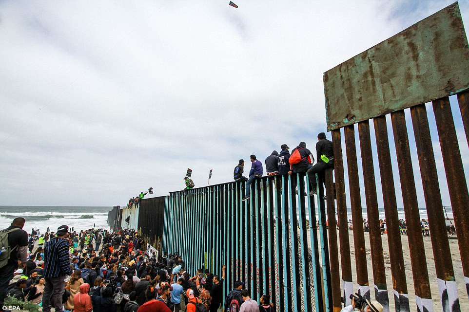 Người di cư trèo lên hàng rào biên giới Mỹ - Mexico - Ảnh 1.