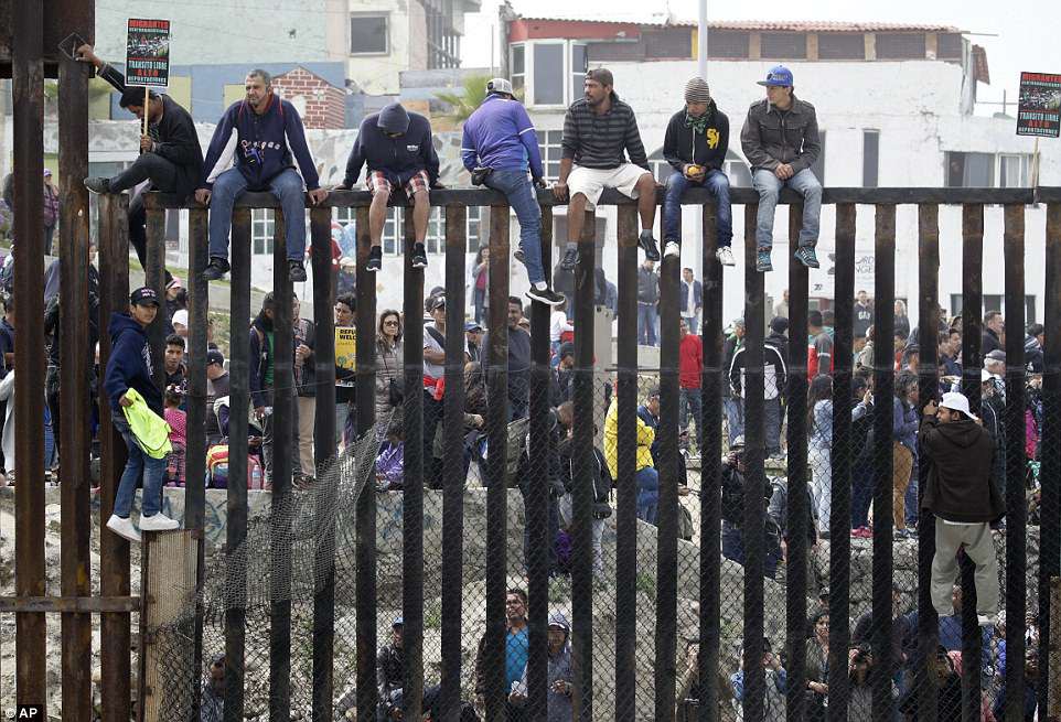 Người di cư trèo lên hàng rào biên giới Mỹ - Mexico - Ảnh 3.