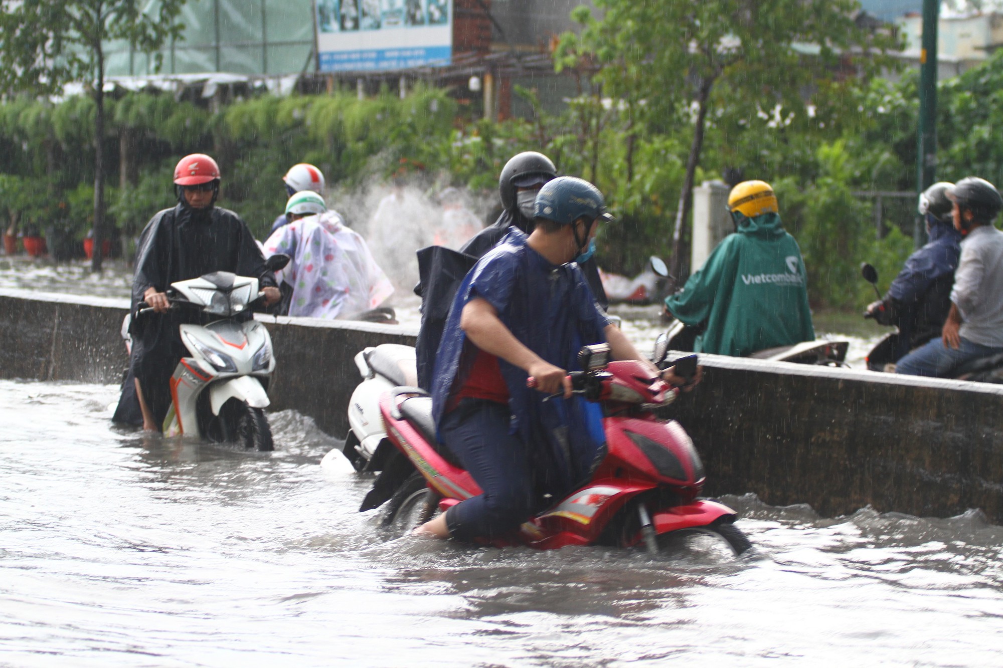CLIP: Nước cuồn cuộn cuốn ngã xe máy trong cơn mưa xối xả ở TP HCM - Ảnh 3.