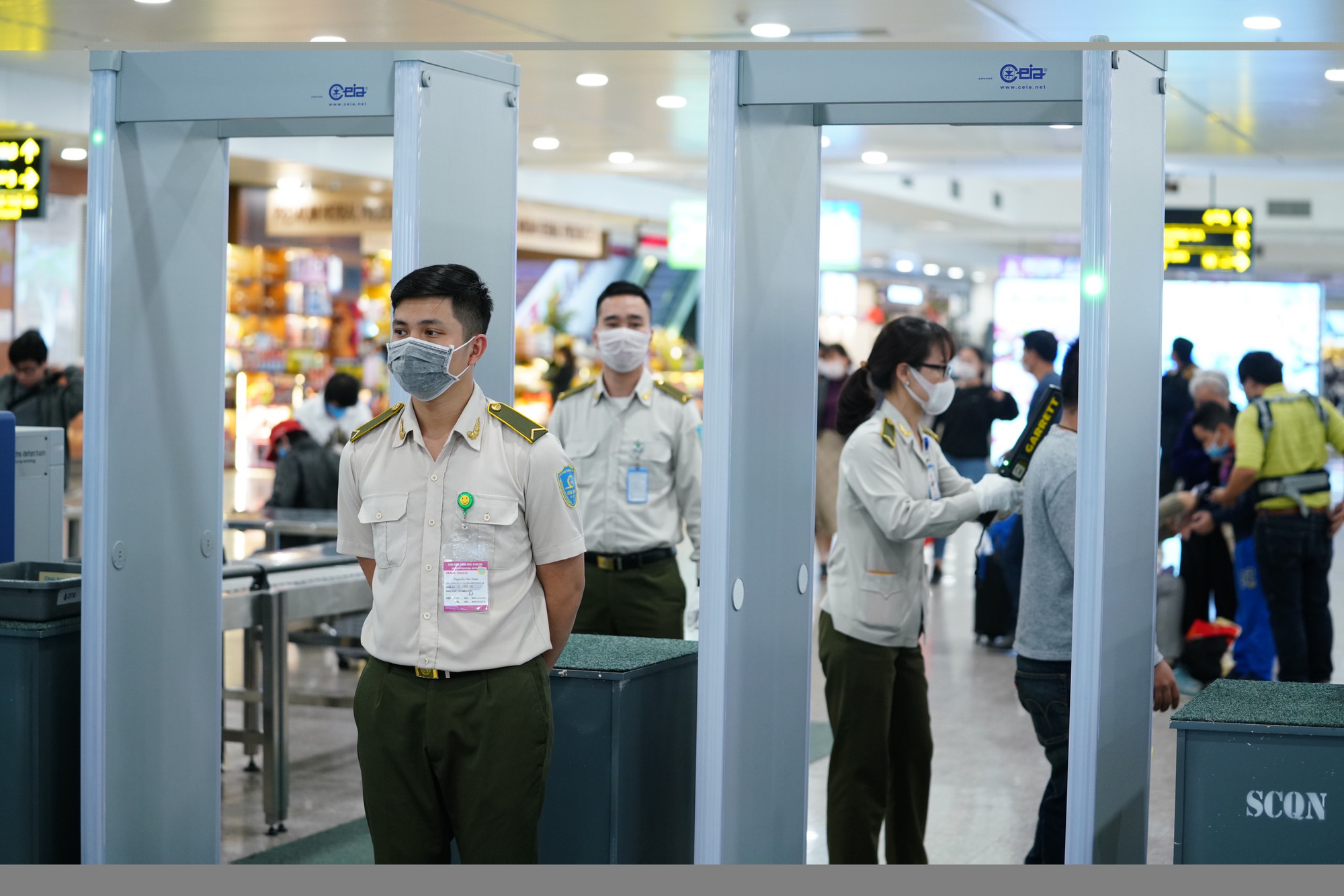 Dòng người đeo khẩu trang tại sân bay Nội Bài - Ảnh 12.