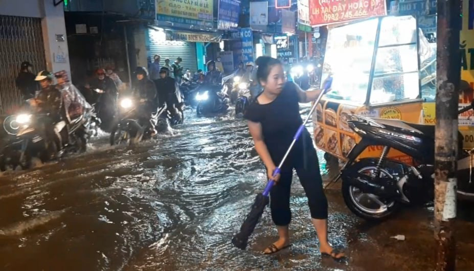 TP HCM: Nước ngập, nhiều người dắt xe trên đường trong mưa lớn - Ảnh 1.