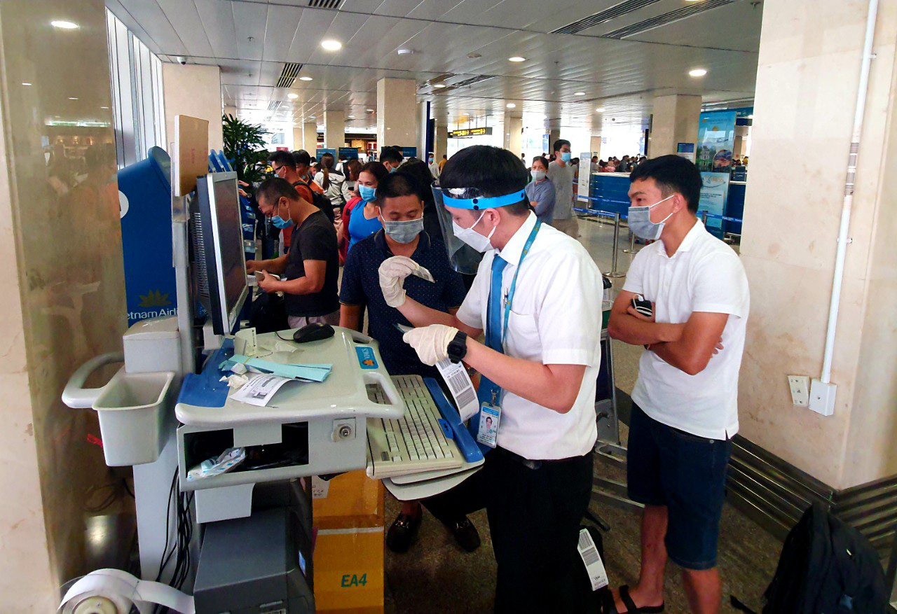 Sân bay Tân Sơn Nhất đông nghẹt ngày 25 Tết, nhiều khách trùm kín người để phòng dịch - Ảnh 7.