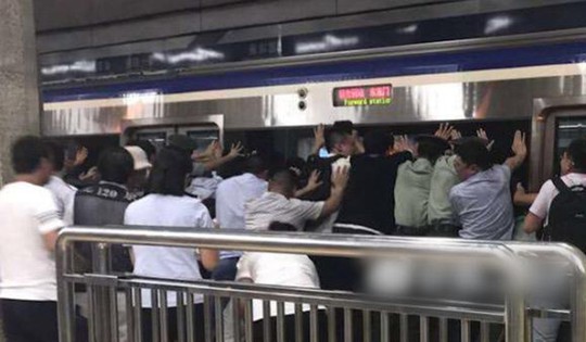 Hàng trăm người đẩy nghiêng tàu điện ngầm, cứu nạn nhân mắc kẹt - Ảnh 3.