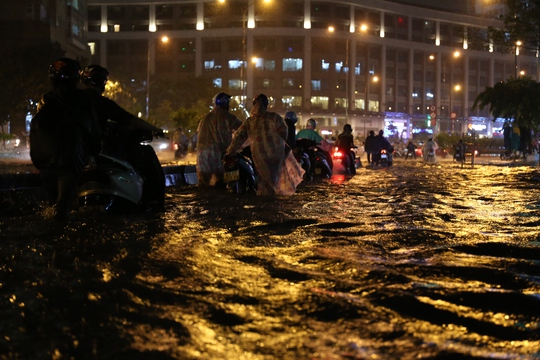 CSGT dầm mưa giúp dân qua đoạn ngập ở Sài Gòn - Ảnh 2.