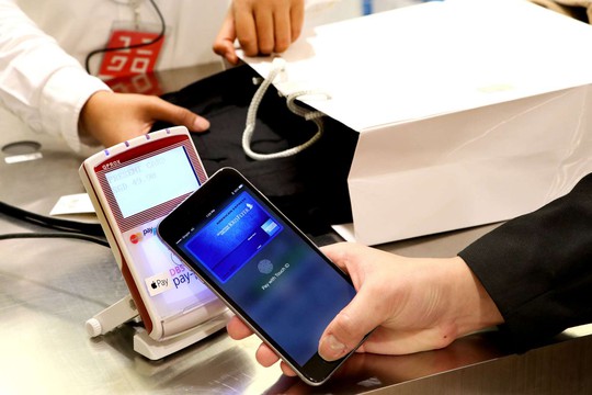 Một khách hàng dùng ví điện tử Apple Pay trả tiền mua hàng ở Singapore Ảnh: STRAITS TIMES