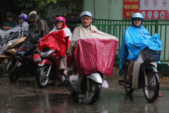 Phụ huynh chờ con thi THPT trong cơn mưa chiều tầm tã - Ảnh 1.