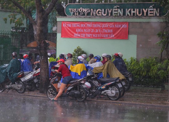 Phụ huynh chờ con thi THPT trong cơn mưa chiều tầm tã - Ảnh 2.