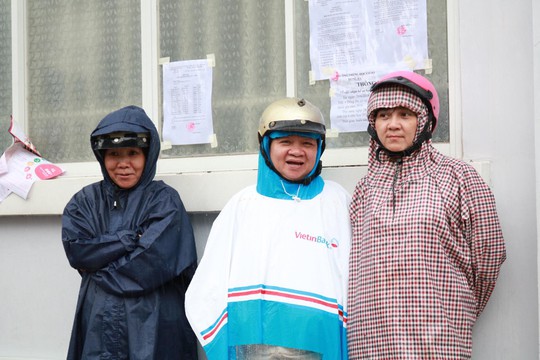 Phụ huynh chờ con thi THPT trong cơn mưa chiều tầm tã - Ảnh 4.