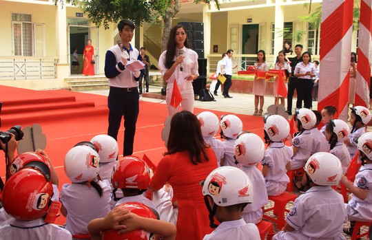 Hoa hậu Lương Thùy Linh trao mũ bảo hiểm cho học sinh trong ngày khai giảng - Ảnh 8.