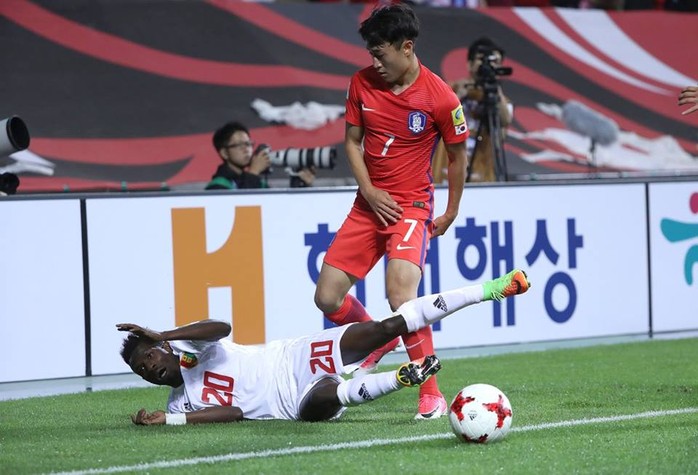 
Jules Suzuki của Guinea té ngã sau pha tranh bóng với Jin-Hyun Lee của Hàn Quốc
