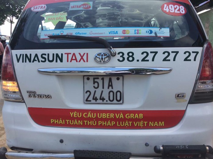 TP HCM: Taxi Vinasun dán bảng phản đối Uber, Grab - Ảnh 1.