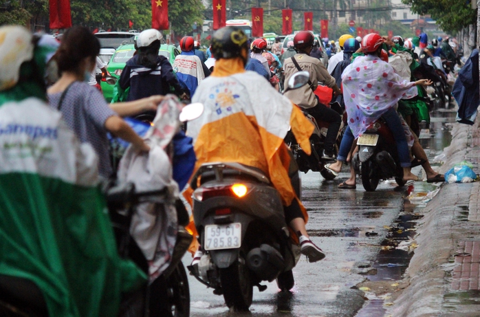 
Khoảng 17 giờ ngày 2-5, một cơn mưa bất ngờ trút xuống khiến người dân chật vật chạy mưa. Trong ảnh: Nhiều người dừng lại bên đường Cộng Hòa để mặc áo mưa.
