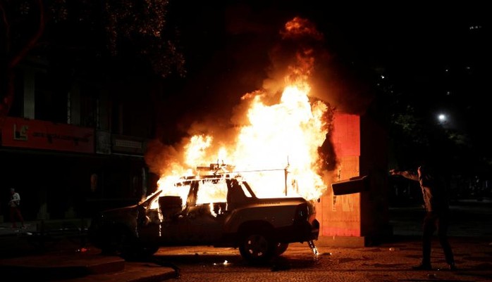 
Hình ảnh một chiếc xe hơi bị thiêu cháy trong cuộc biểu tình. Ảnh: Reuters
