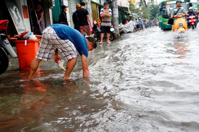 Người dân TP HCM bì bõm sau cơn mưa lớn - Ảnh 3.