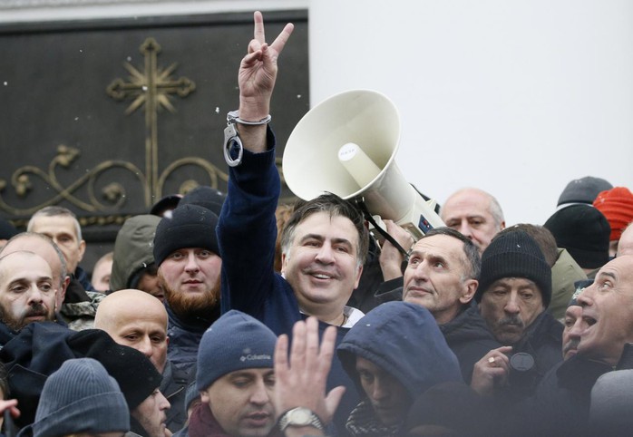 
Saakashvili hoan hỉ sau khi được giải thoát khỏi xe cảnh sát. Ảnh: Reuters
