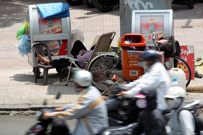 
Trên vỉa hè đường Trần Hưng Đạo (quận 1), một người bán hàng rong không còn sức để mua bán khi ngoài trời nắng như đổ lửa
