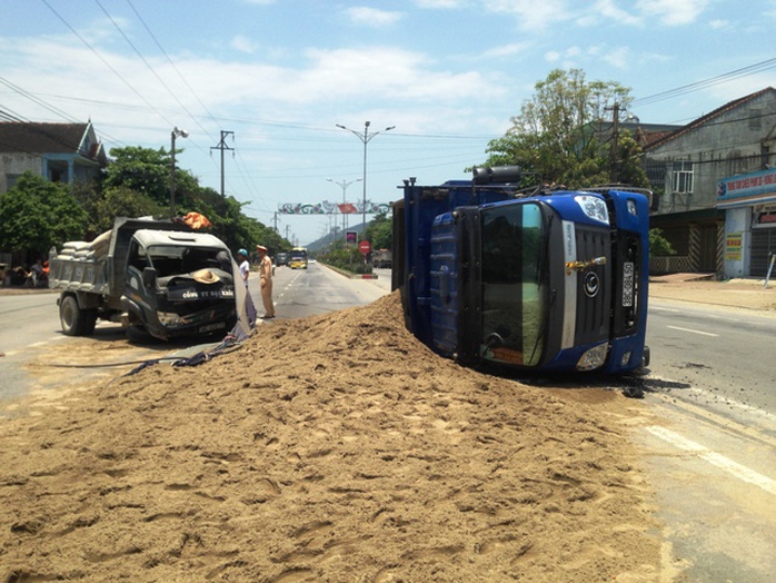 Hiện trường vụ tai nạn khiến một chiếc xe tải nằm lật nghiêng giữa đường