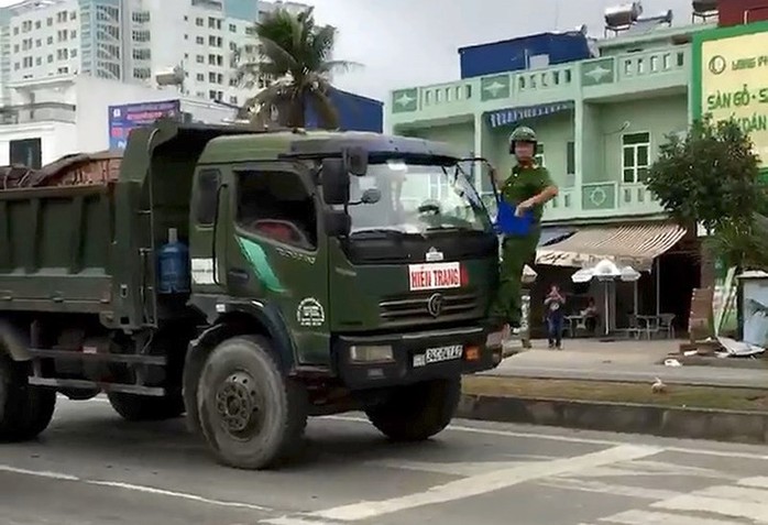 Cảnh sát phải đánh đu trên đầu xe tải - Ảnh 1.