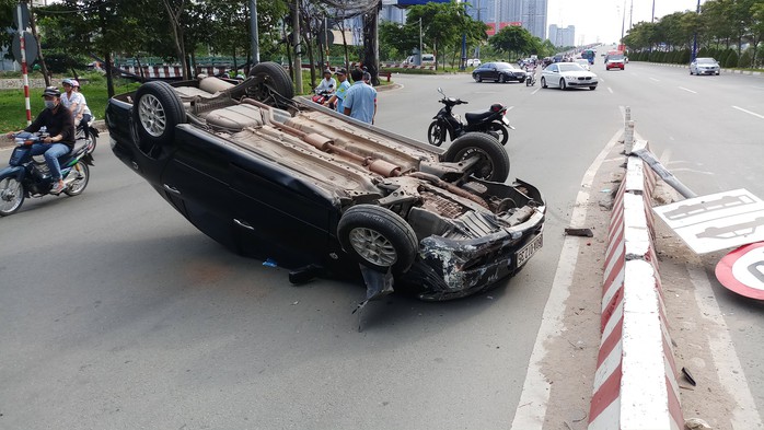 Xế hộp lật như phim ở dốc cầu Sài Gòn - Ảnh 1. Xế hộp lật như phim ở dốc cầu Sài Gòn - Ảnh 1.