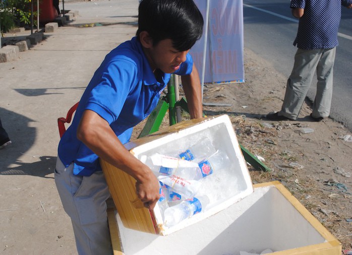 CSGT Đồng Tháp phát nước, khăn lạnh cho người dân trên đường về quê ăn Tết - Ảnh 1.