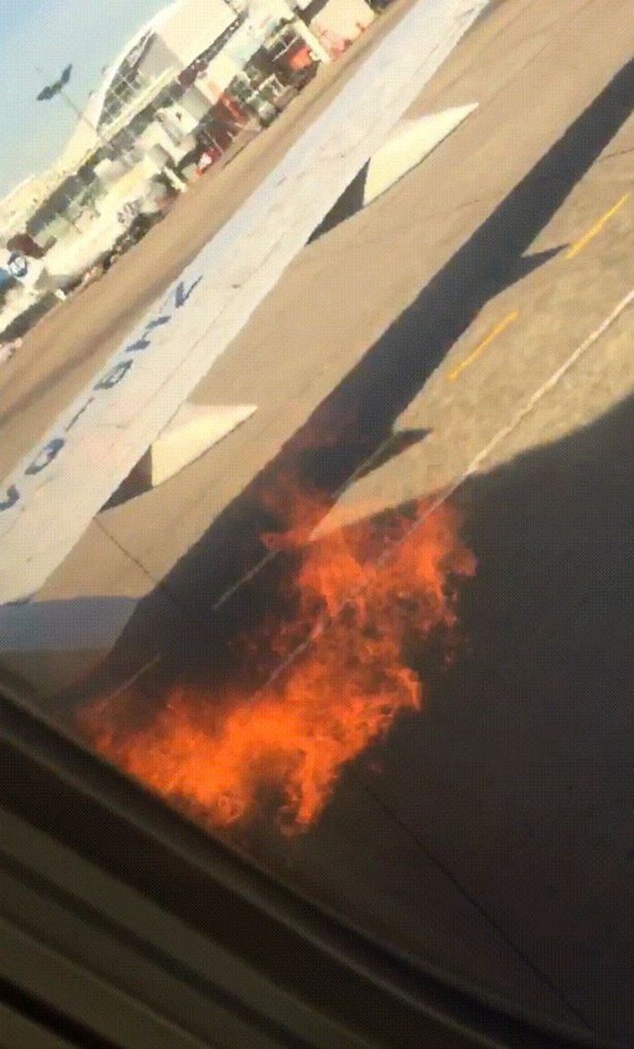 Động cơ cháy, hành khách mở cửa nhảy lên cánh máy bay thoát thân - Ảnh 1.