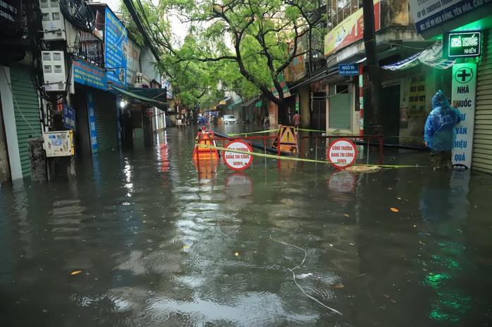 Hà Nội ngập sâu, sinh hoạt của người dân đảo lộn sau cơn mưa lớn - Ảnh 6.