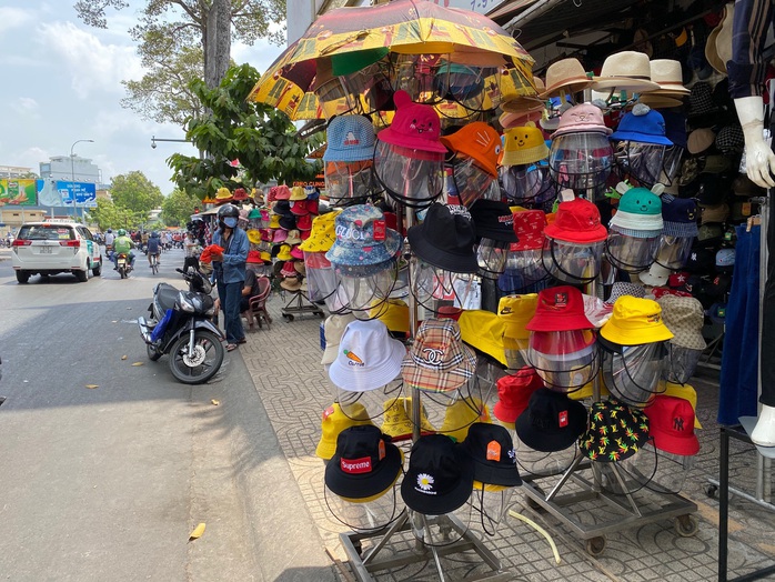 Nón, áo phòng dịch Covid-19 bán đầy đường và chợ mạng - Ảnh 1.