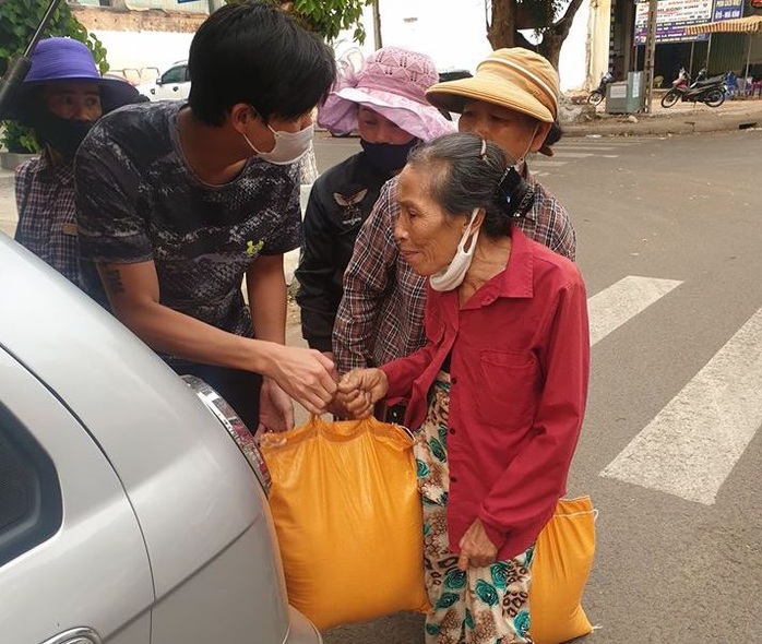 Hai người đàn ôngchạy vòng vòng phát gạo cho người bán vé số - Ảnh 1.