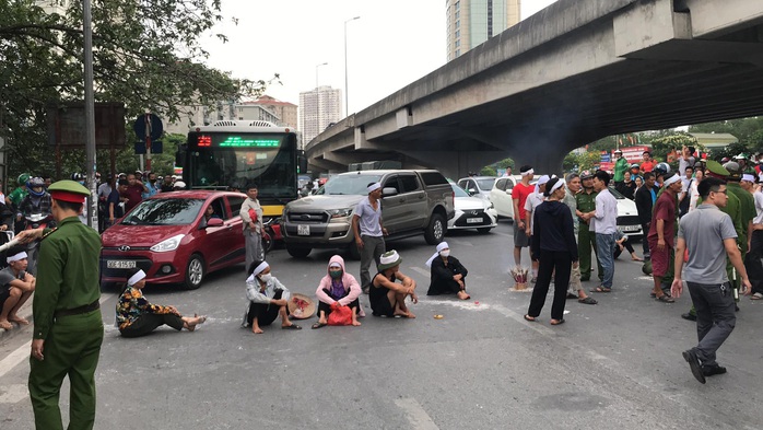 Hàng chục người mang di ảnh người thân bị tai nạn giao thông ngồi dàn hàng ngang ra đường - Ảnh 1.