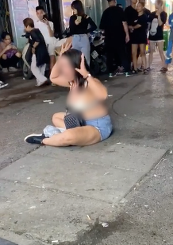 Cô gái cởi áo ăn vạ ngay trên phố khi bị nhóm nhân viên quán bar khiêng ra ngoài đường - Ảnh 2.