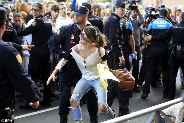 Fury: A demonstrator blocking the road to stop the van transporting Excalibur is removed by a police officer, outside the housing development in which the nurse lives in Alcorcon, outside Madrid