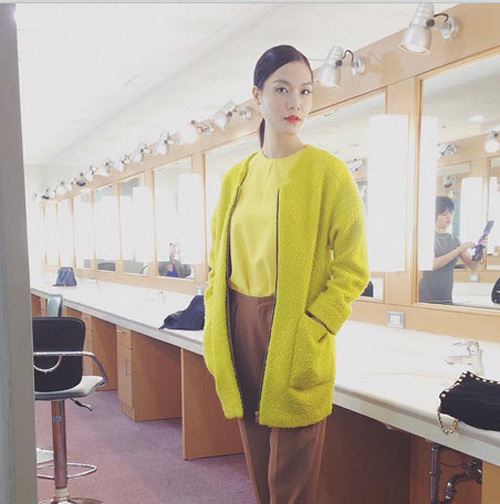 Hoa hậu Thùy Dung diện chiếc áo khoác màu vàng chanh rất nổi khi kết hợp cùng quần vải màu nâu đất