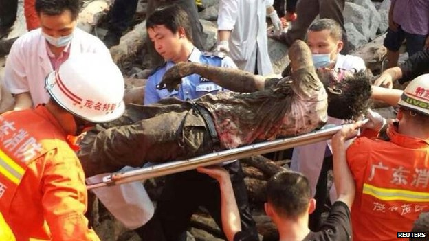 Rescue workers carry an injured man after a bridge collapsed during construction in Maoming, Guangdong province, 3 May 2014