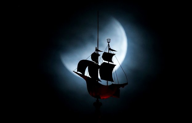 Moon behind galleon weather vane