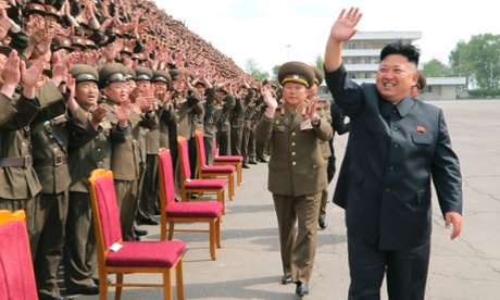 North Korean leader Kim Jong-un waves during a photo session with soldier-builders in this undated photo released by North Koreas Korean Central News Agency