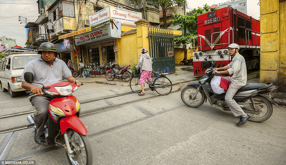 Crossing: Mr Desai said the locals know when the train is coming so they all move out of the way - it is a part of their routine