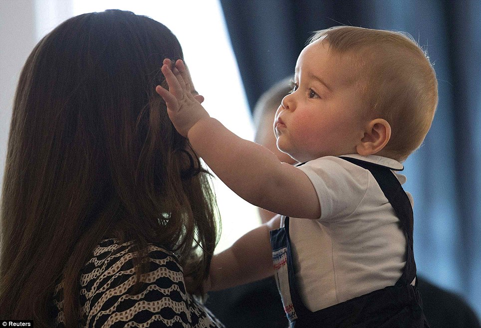The young royal appeared more interested with his mothers hair than the other children and was seen gently pulling her brunette tresses away from the Duchess face