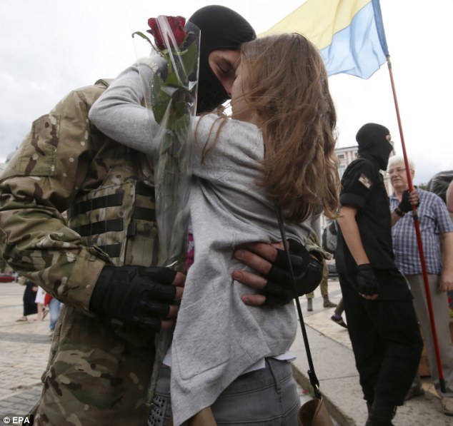 Tearful goodbye: A volunteer recruit embraces his girlfriend after the oath of allegiance ceremony outside Kiev