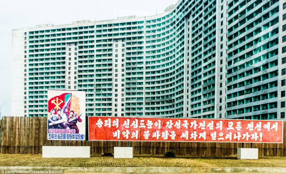 Ad fad: There are no adverts in North Korea, instead billboards are covered with propaganda posters such as this one urging people to work harder for their country