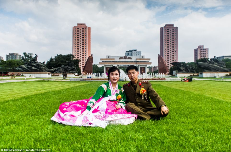 Just married: This newlywed couple  couple are photographed sitting on the grass near a fountain in Pyongyang, North Korea, just after their big day