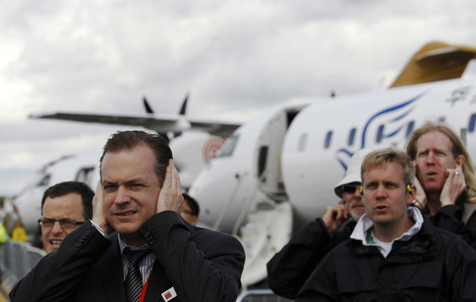 Spectators cover their ears as a Eurofighter Typhoon jet takes off at the Farnborough Airshow 2012 in southern England July 10, 2012. (Reuters/Luke MacGregor)