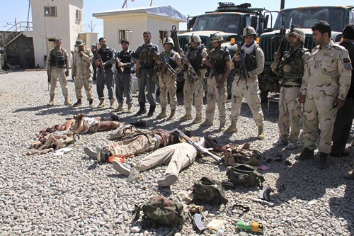 Afghan security forces gather around the bodies of dead Taliban insurgents at the site of a suicide attack in Ghazni Province September 4, 2014