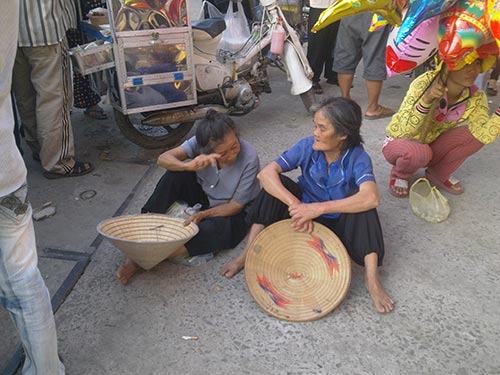 Hai cụ già ngồi ngay cổng chùa Hoằng Pháp chờ khách vào viếng chùa bố thí