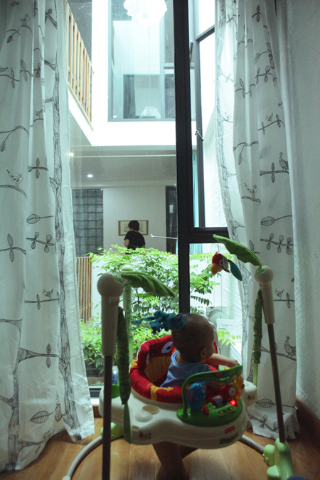 Nhờ có giếng trời và cửa kính, từ phòng khách, bố mẹ vẫn có thể dễ dàng quan sát cậu con trai nhỏ đang chơi trong phòng.